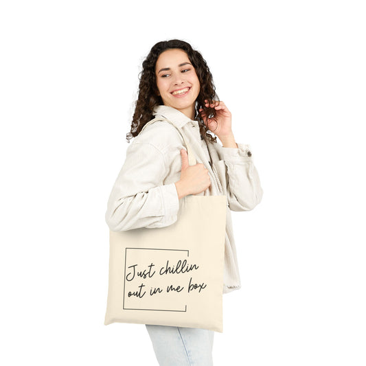Woman carrying a natural canvas tote bag featuring the Niall Horan quote “Just chillin out in me box” in black handwritten lettering.