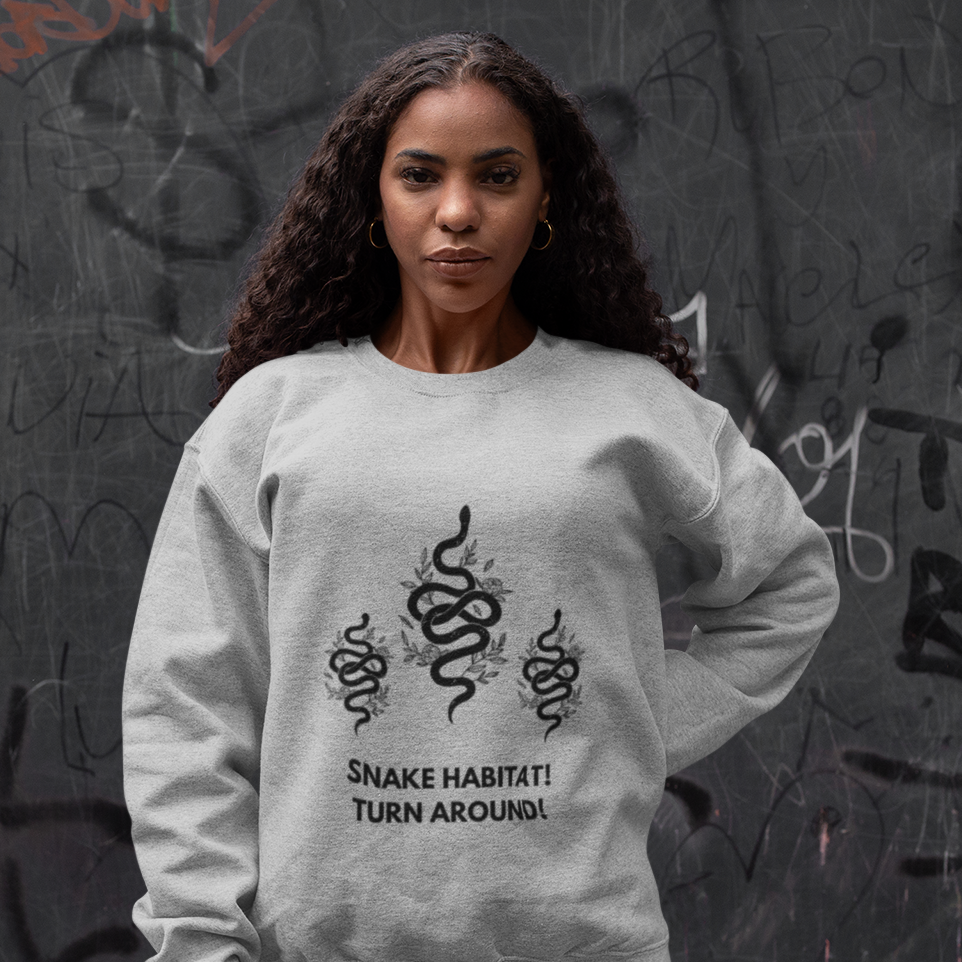 Woman wearing a gray One Direction inspired sweatshirt with Liam Payne’s “Snake Habitat! Turn Around!” design printed with three black snakes.